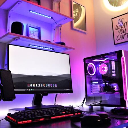 A gaming office setup with a monitor, computer, keyboard and mouse all in very dark colours.