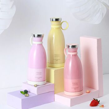 Trois blender Fresh Juice de couleur rose, blanc et jaune remplis de smoothies roses, mauve et jaune, sur un fond blanc.