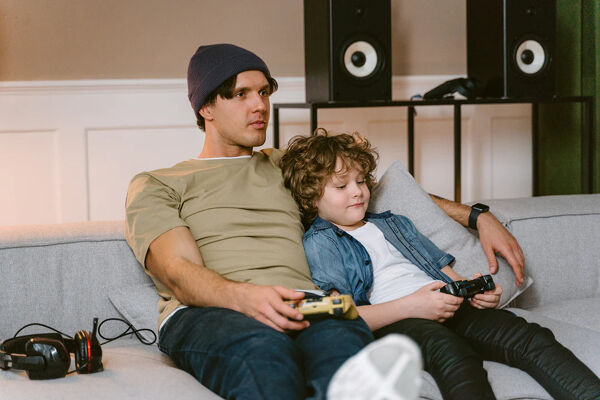 A child and his father on a sofa playing a game with the RetroWave console from Niye.